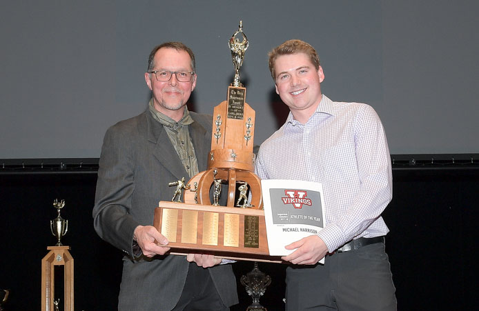 George Fabi of The Chopped Leaf Camrose presents Michael Harrison with the Male Athlete of the Year Award